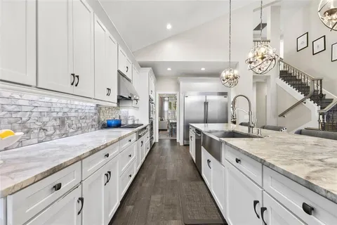 a large kitchen with stainless steel appliances granite countertop a lot of counter space and wooden floor