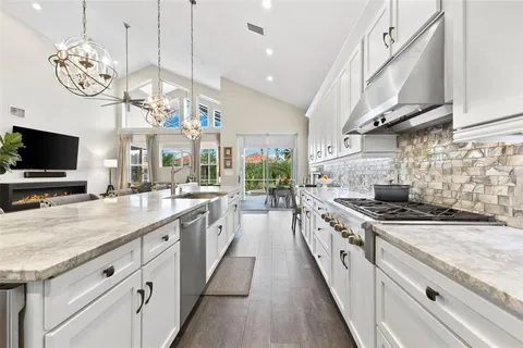 a kitchen with stainless steel appliances granite countertop a stove oven and a white cabinets