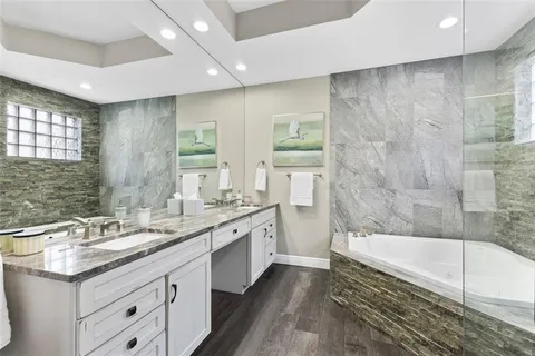 a bathroom with a granite countertop sink a toilet and shower