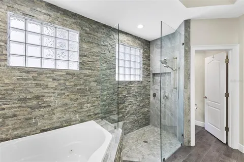 a spacious bedroom with a bed and wooden floor