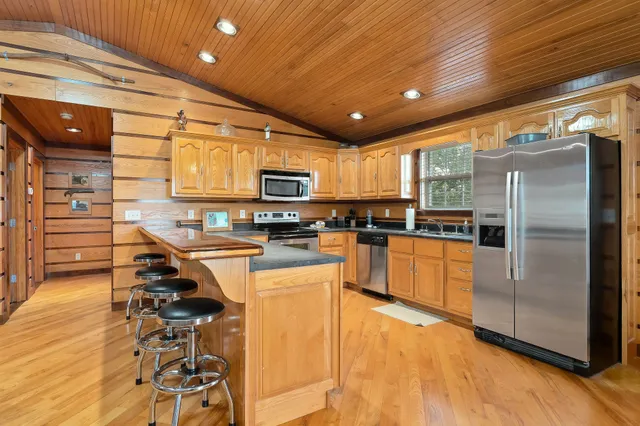 a kitchen with stainless steel appliances kitchen island granite countertop a stove a sink and a refrigerator