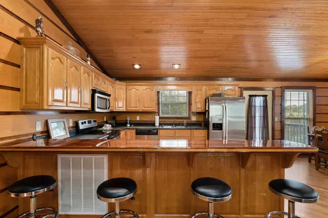 a kitchen with stainless steel appliances granite countertop a sink a stove and a wooden cabinets