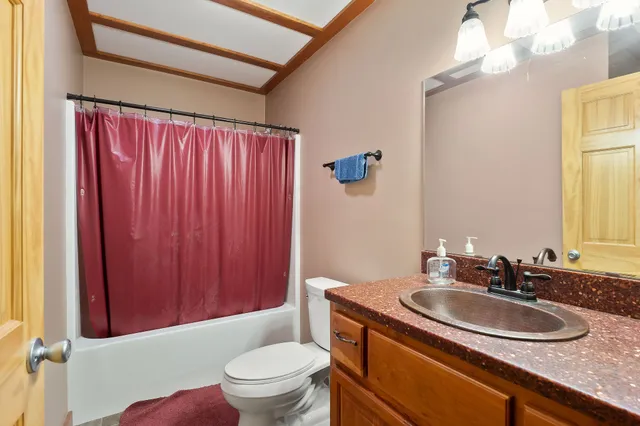 a bathroom with a sink a toilet and shower curtain