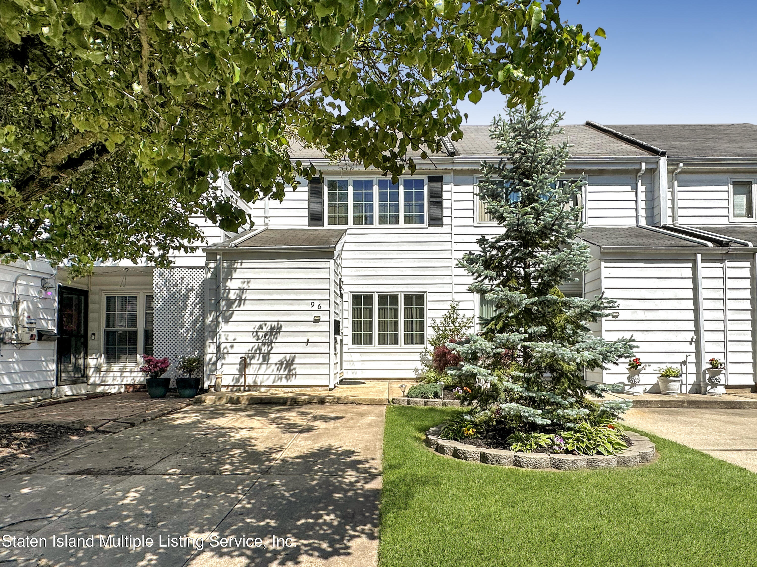 96 Hampton Green Staten Island, NY 10312 - Photo 2 of 24 a front view of a house with a yard and garage