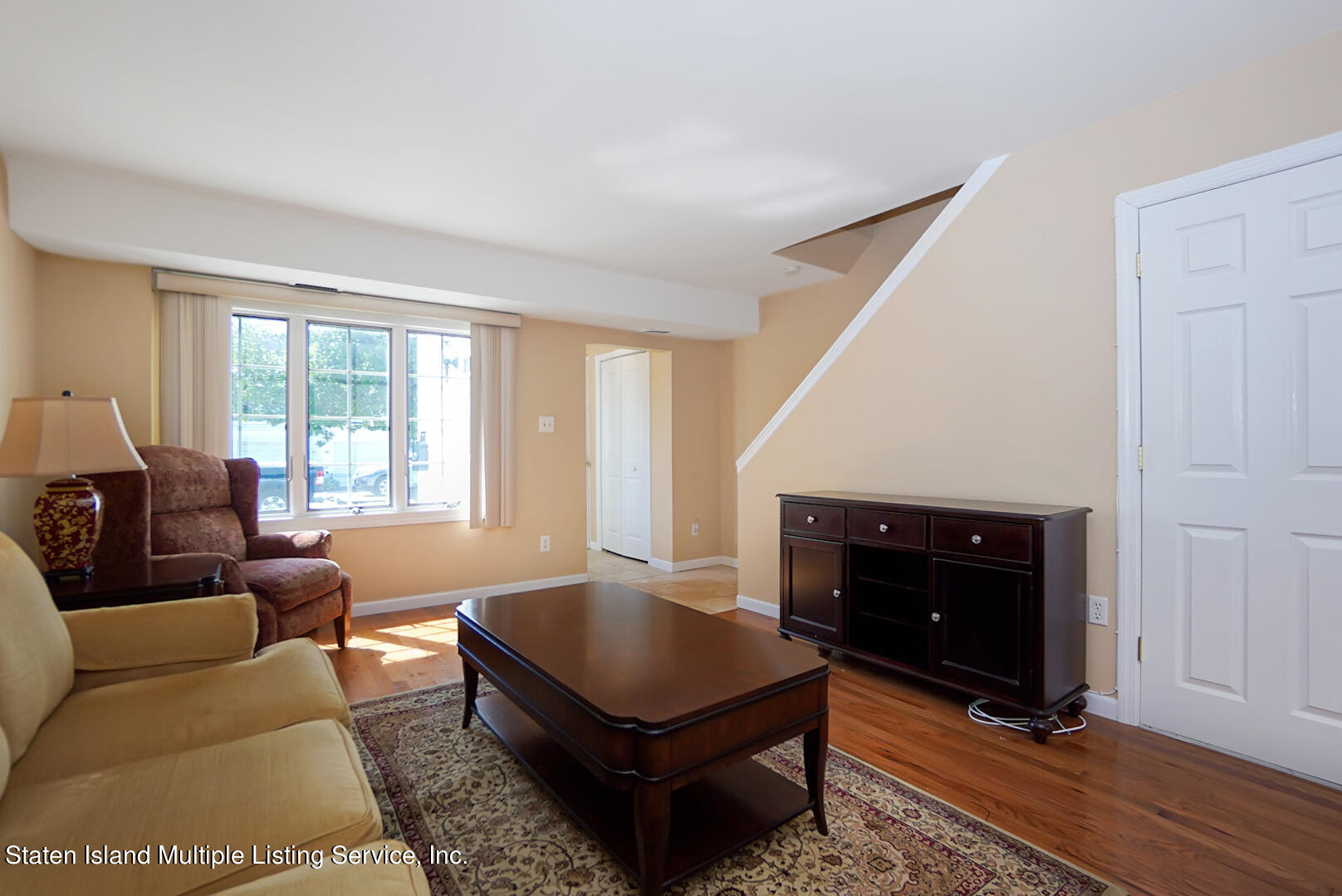96 Hampton Green Staten Island, NY 10312 - Photo 7 of 24 a living room with furniture a rug and a fireplace