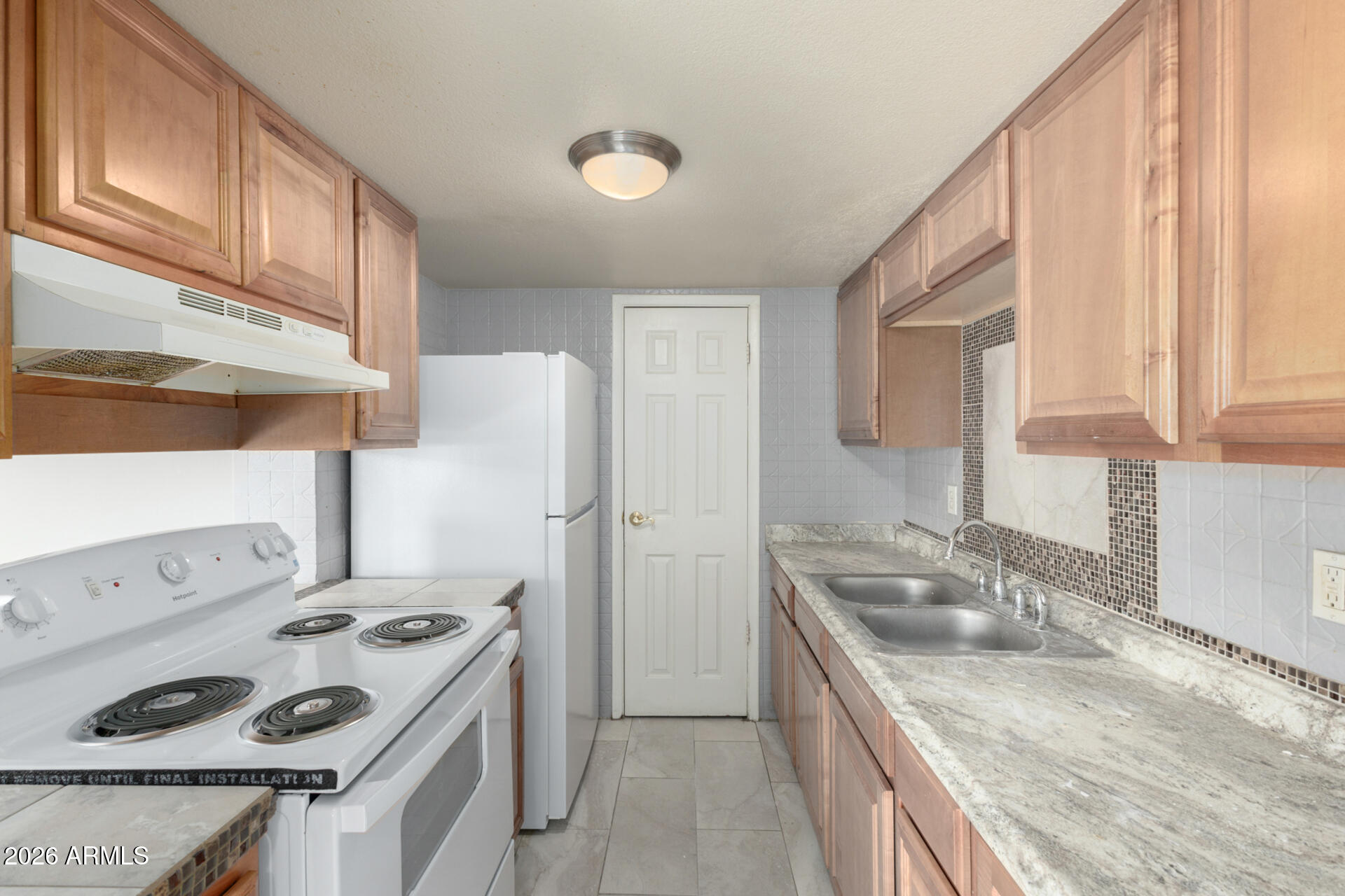 3936 West Camelback Road Phoenix, AZ 85019 - Photo 7 of 19 a kitchen that has a sink a stove and a refrigerator