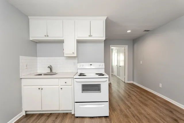 a kitchen with granite countertop white cabinets and white appliances