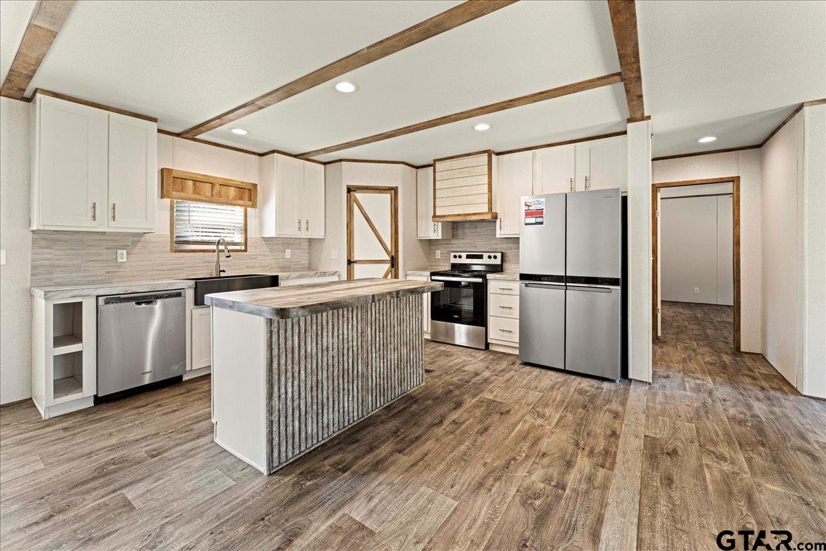 4776 County Road 4509 Athens, TX 75752 - Photo 11 of 25 a kitchen with stainless steel appliances granite countertop a stove a sink dishwasher a refrigerator and cabinets with wooden floor