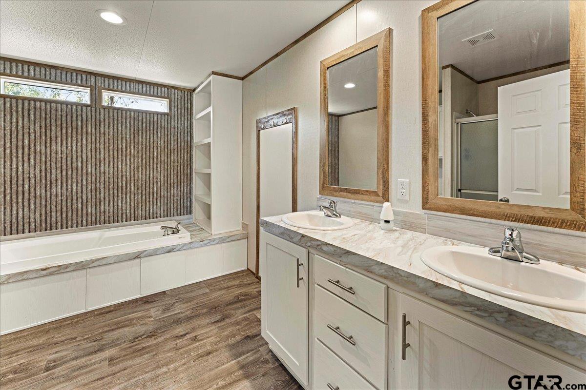 4776 County Road 4509 Athens, TX 75752 - Photo 14 of 25 a bathroom with a granite countertop double vanity sink a mirror and a bathtub