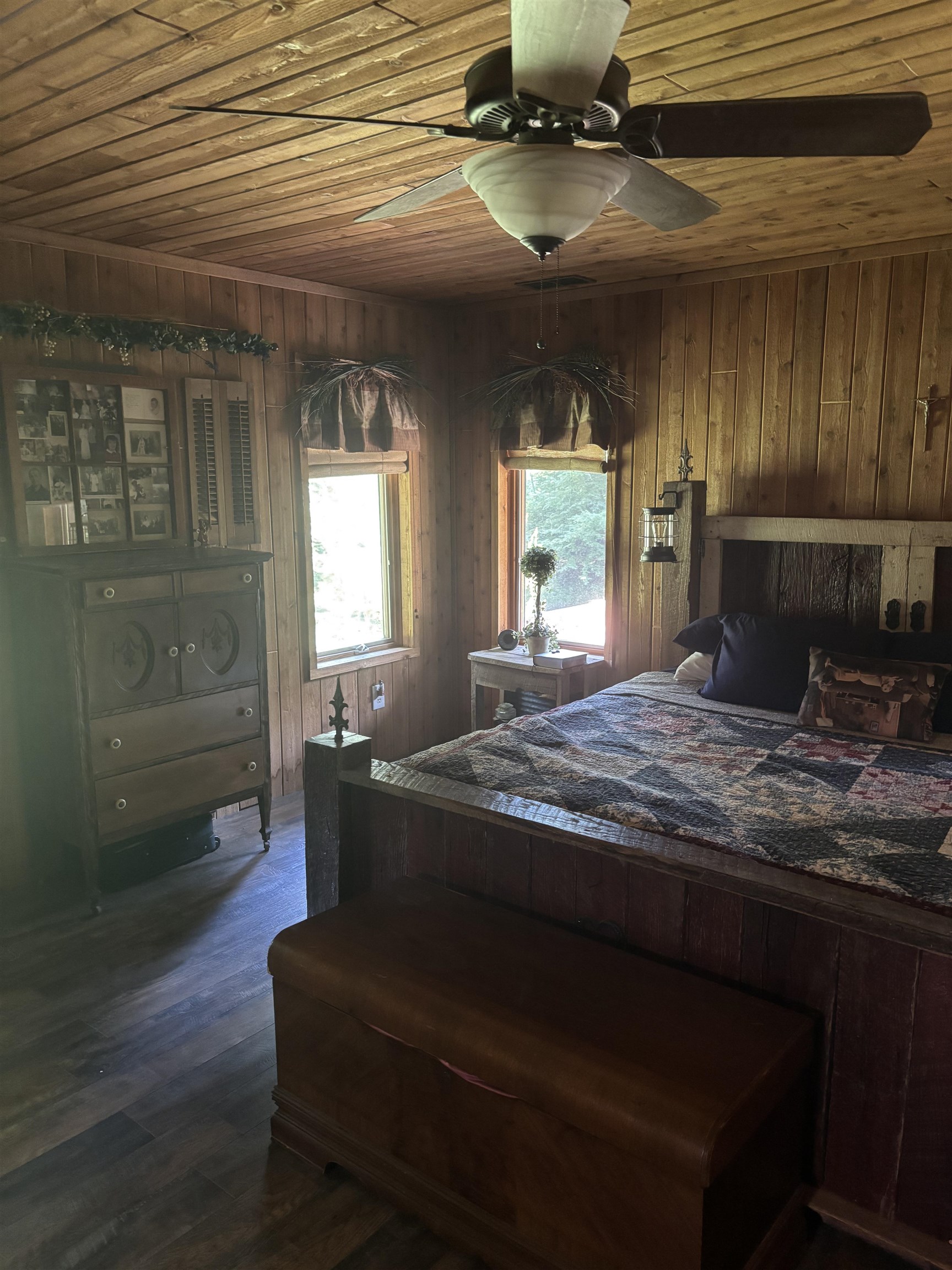 7462 Campground Road Drummonds, TN 38023 - Photo 13 of 31 Wood paneling throughout, ceiling-mounted fan with integrated lighting, two windows with natural light, and wood-finish flooring