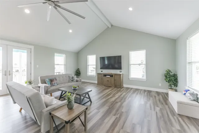 a living room with furniture a flat screen tv and a large window