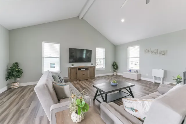 a living room with furniture a window and a flat screen tv