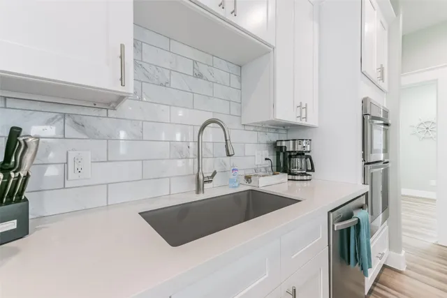 a kitchen with stainless steel appliances a sink a refrigerator a counter space and cabinets