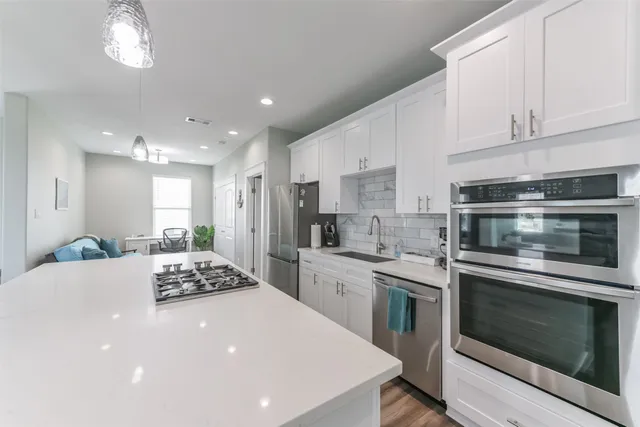 a kitchen with stainless steel appliances kitchen island granite countertop a stove sink and cabinets