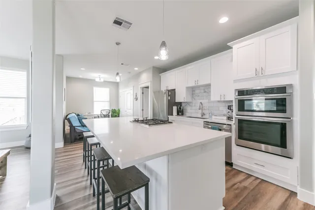 a kitchen with kitchen island a stove a table and chairs