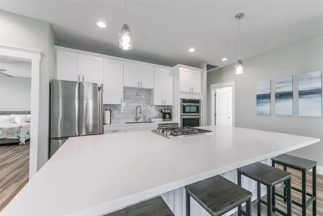 a kitchen with kitchen island a refrigerator stove and microwave