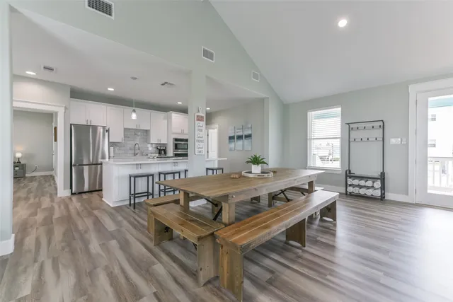 a living room with stainless steel appliances kitchen island granite countertop furniture wooden floor and a rug