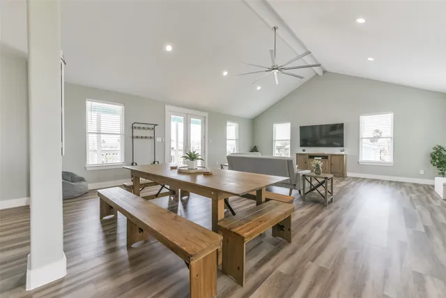 a living room with furniture a flat screen tv and wooden floor