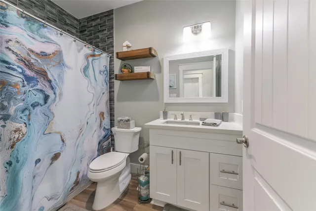 a bathroom with a granite countertop toilet sink and mirror
