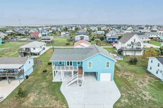 an aerial view of a house with garden space and ocean view