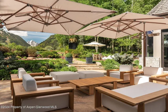 a view of a white house with a big yard and large tree