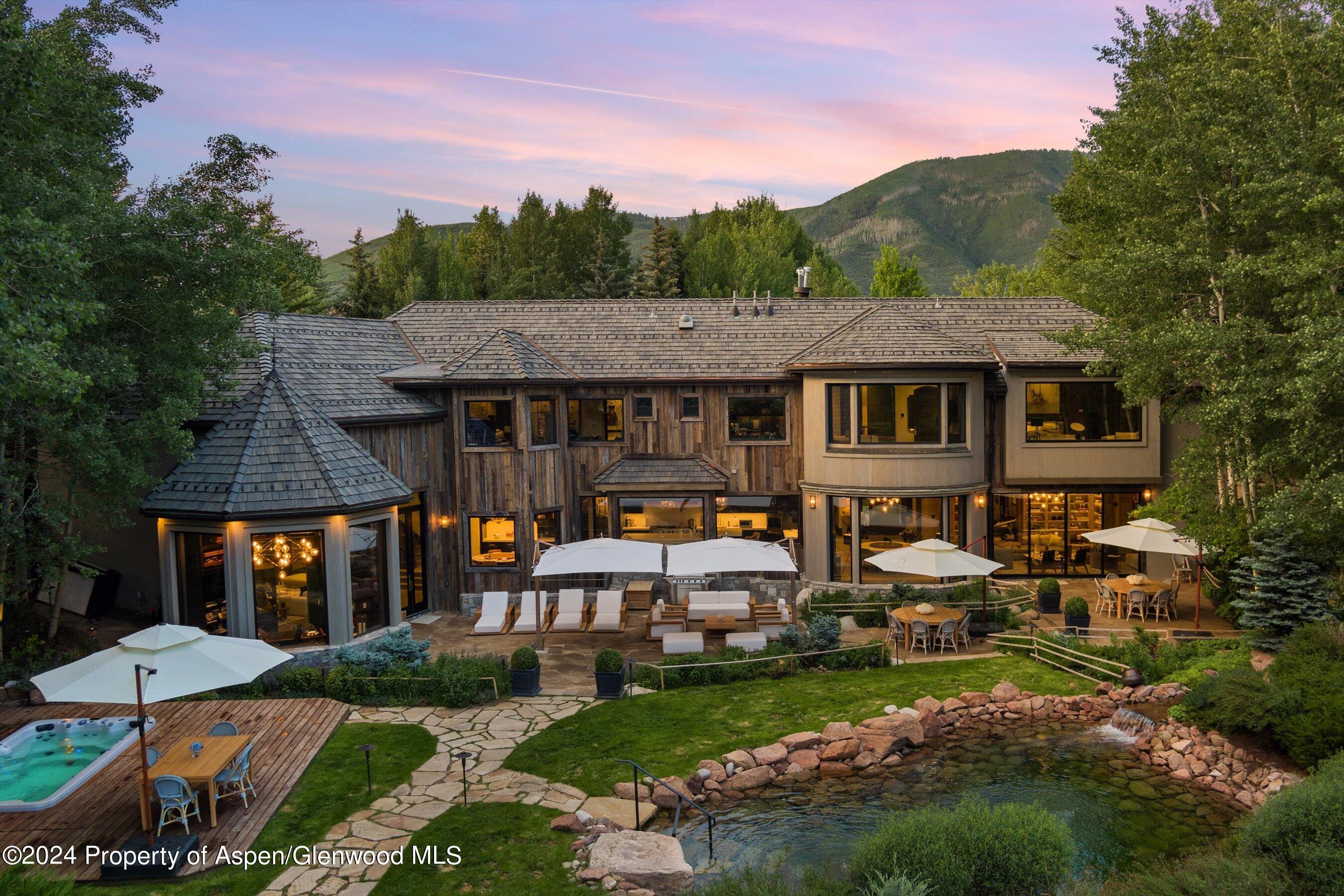 73 Hideaway Lane Aspen, CO 81611 - Photo 3 of 100 a view of a white house with a big yard and large tree