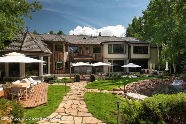 a view of a house with backyard sitting area and garden