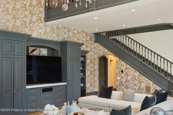 a bedroom with bed a mirror and a flat tv screen on dresser