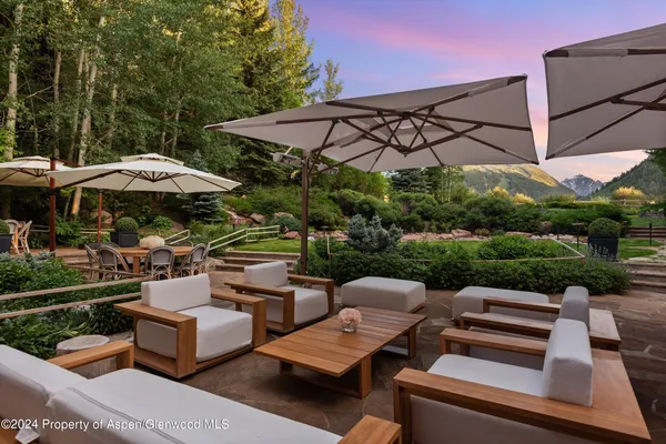 a view of a chairs and table in backyard