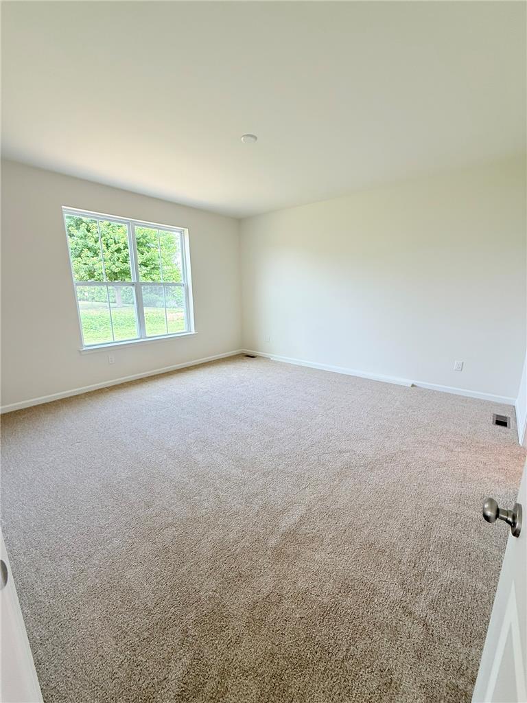 328 Abby Road, Unit LOT 15 Macungie, PA 18062 - Photo 15 of 26 A well-lit, neutral-toned room features a broad window and plush carpeting.