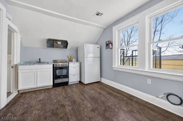 a view of kitchen with a refrigerator cabinets and wooden floor