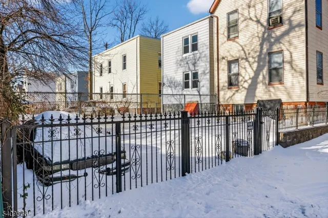 a view of a brick house with iron fence