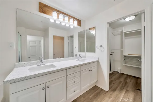 a spacious bathroom with a granite countertop sink a mirror and a shower