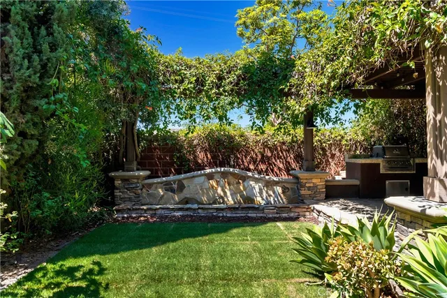 a view of a backyard with couches plants and large trees