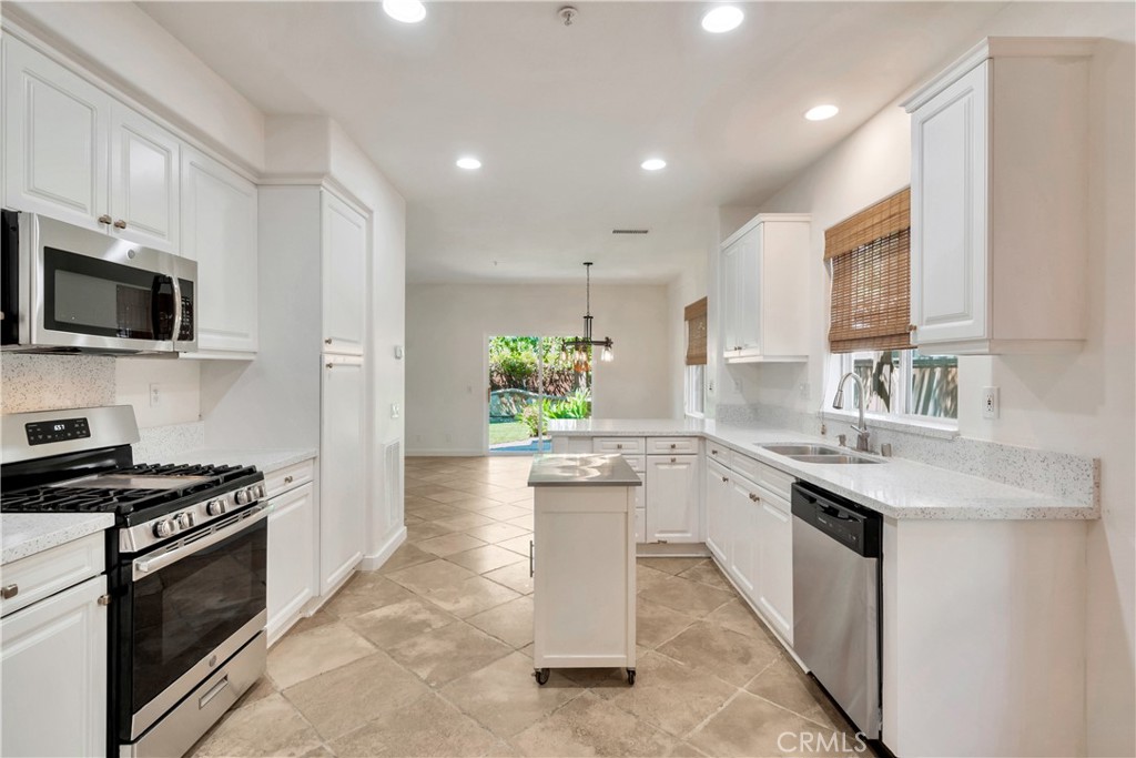 5 Flowerdale Ladera Ranch, CA 92694 - Photo 7 of 22 a kitchen with stainless steel appliances kitchen island granite countertop a stove sink and cabinets
