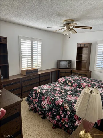 a bedroom with a bed and a flat tv screen on the dresser