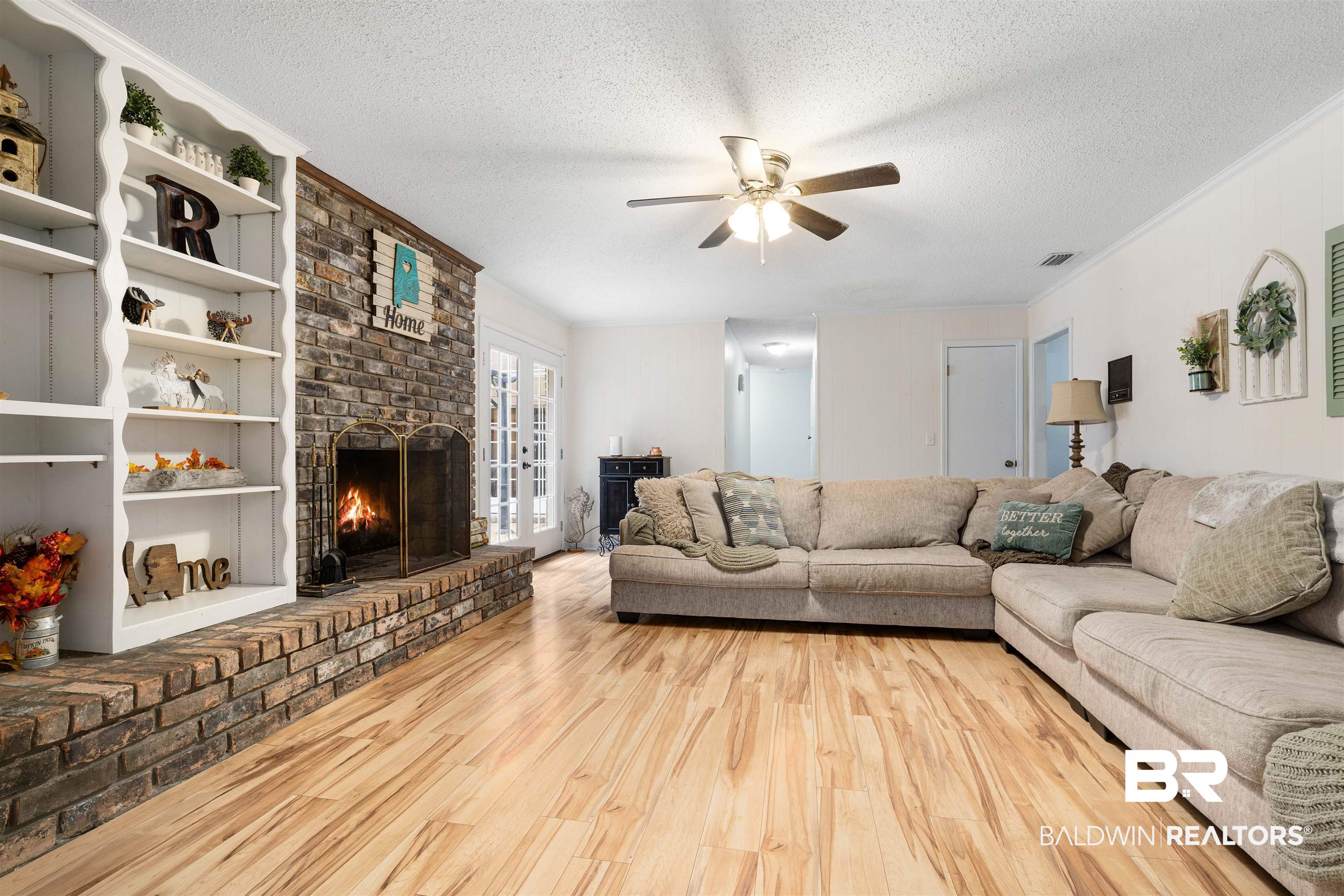 7807 Yorkhaven Road Mobile, AL 36695 - Photo 5 of 34 Living room featuring wood finished floors, a textured ceiling, a fireplace, ornamental molding, and ceiling fan