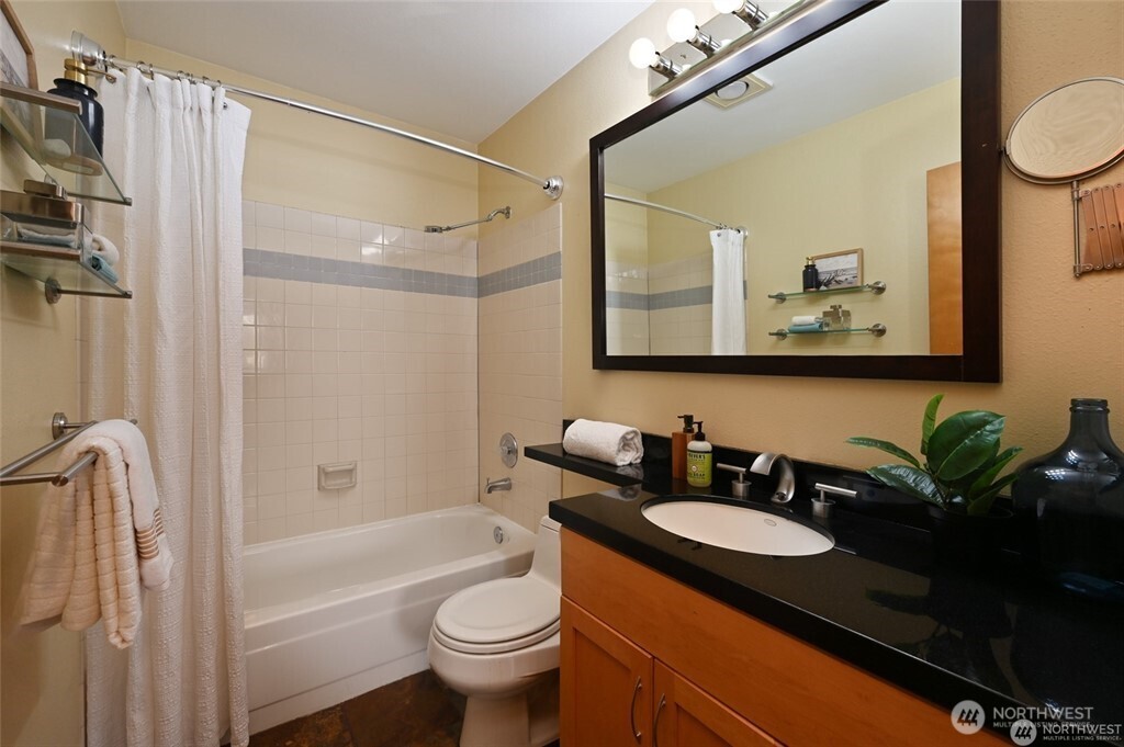 4226 Beach Drive Southwest, Unit 303 Seattle, WA 98116 - Photo 14 of 21 a bathroom with a granite countertop sink toilet and shower