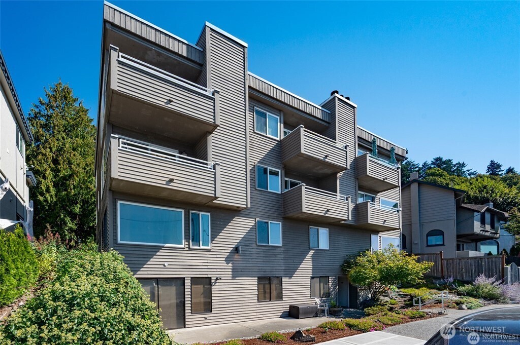 4226 Beach Drive Southwest, Unit 303 Seattle, WA 98116 - Photo 17 of 21 a front view of a house with a yard