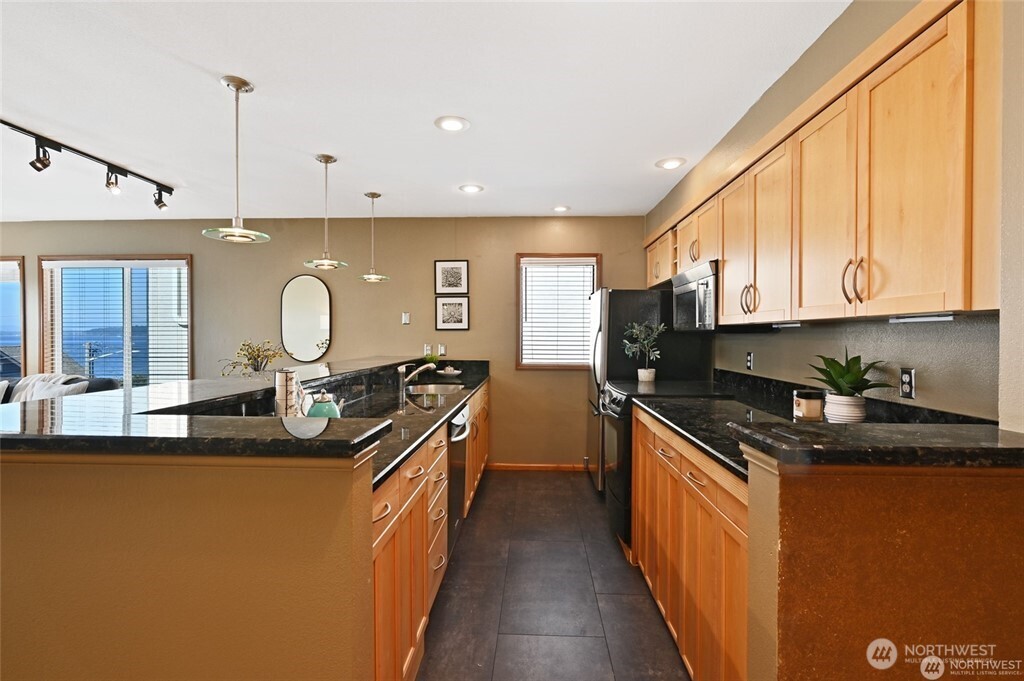 4226 Beach Drive Southwest, Unit 303 Seattle, WA 98116 - Photo 8 of 21 a kitchen with stainless steel appliances granite countertop a sink stove and refrigerator