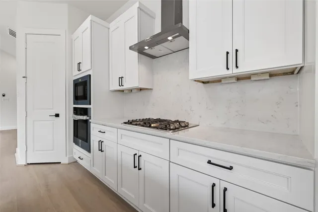a kitchen with stainless steel appliances white cabinets and a stove