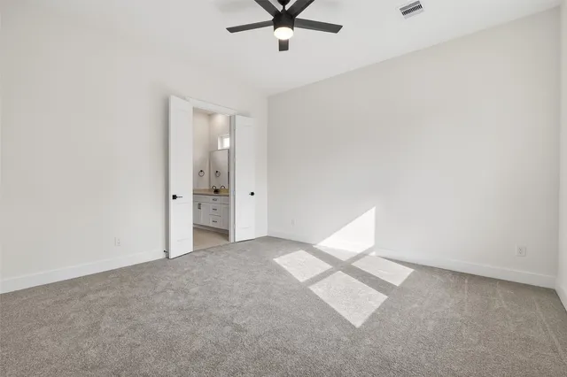 an empty room with closet and fan