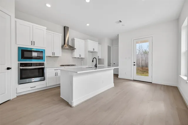 a kitchen with stainless steel appliances granite countertop a stove a sink and a microwave