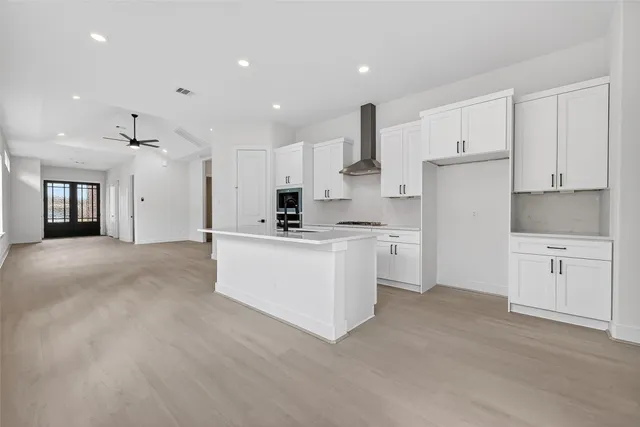 a kitchen with white cabinets and refrigerator