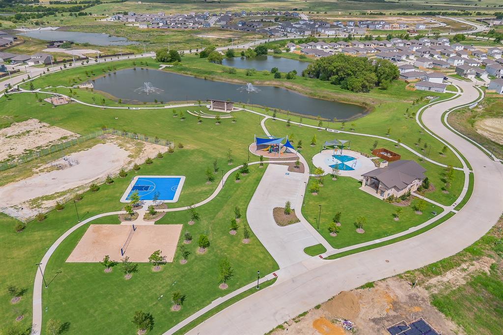 8125 White Sulphur Road Ponder, TX 76259 - Photo 38 of 38 Community park featuring a large pond with fountains, a basketball court, sand volleyball court, and a children's play area with a splash pad