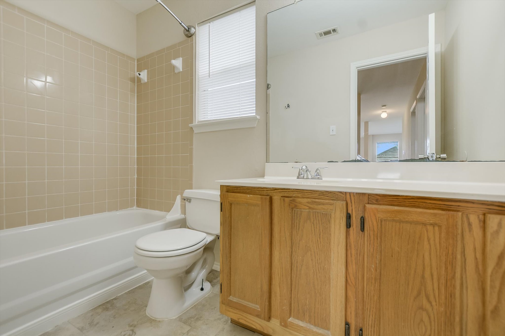 1008 Double File Trail Round Rock, TX 78665 - Photo 16 of 20 Tiled bath and shower with a wood vanity for everyday ease.