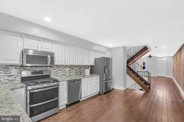 a kitchen with stainless steel appliances a stove microwave and refrigerator