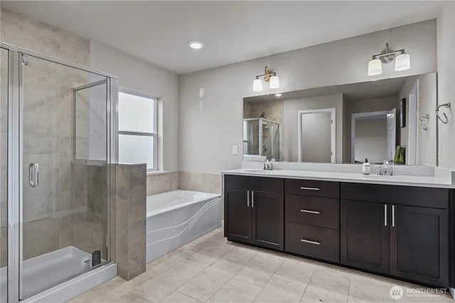 a bathroom with a tub a double vanity sink and a mirror