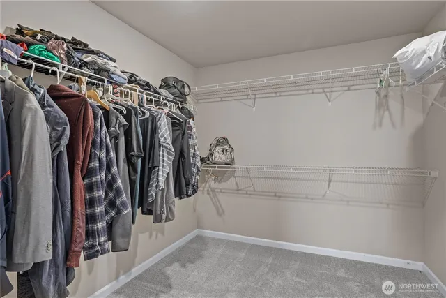 a view of walk in closet with clothes and shoes