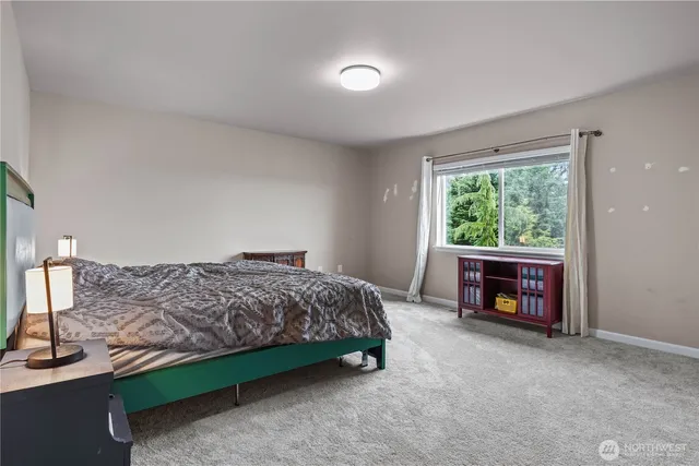 a spacious bedroom with a bed and a window